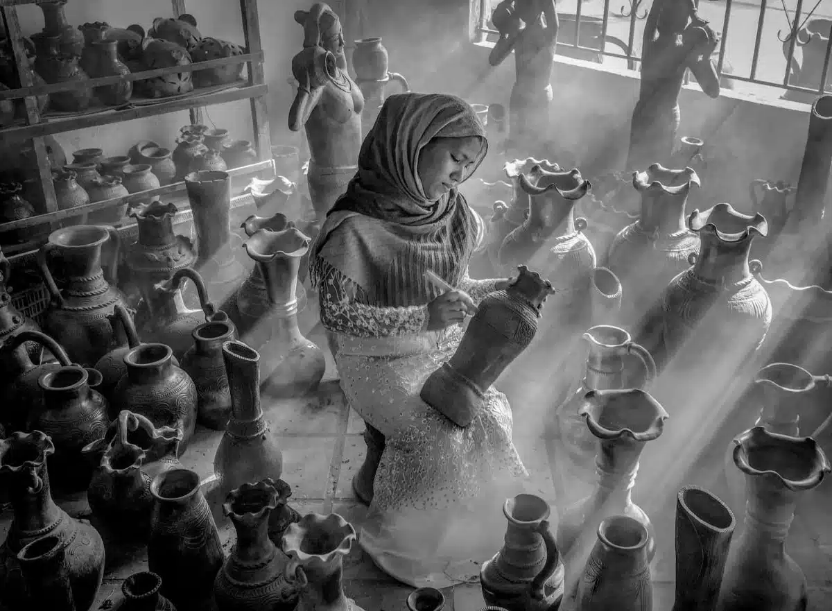 Woman with a headscarf decorating pottery